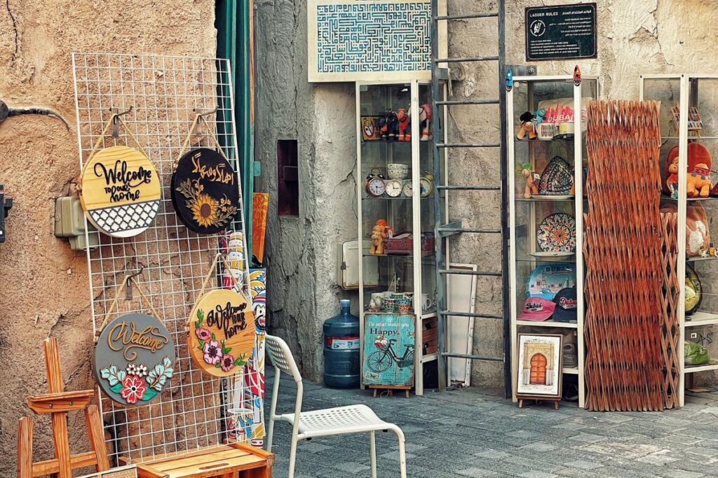 Loja de rua com diversos itens de artesanato local à venda, como placas decorativas e outros souvenirs culturais.