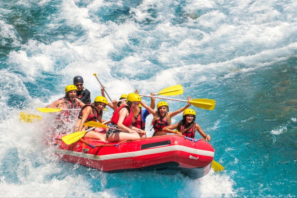 Grupo praticando rafting em águas bravas com bote inflável, esporte aquático radical descoberto viajando em rios