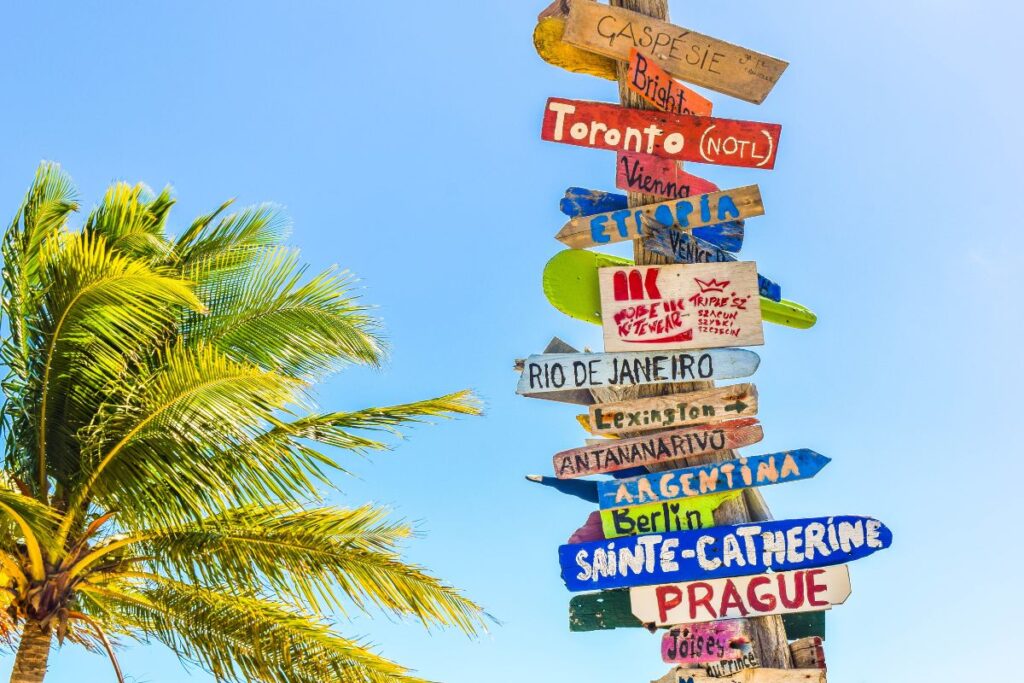 Placa colorida com destinos de viagens pelo mundo incluindo Rio de Janeiro